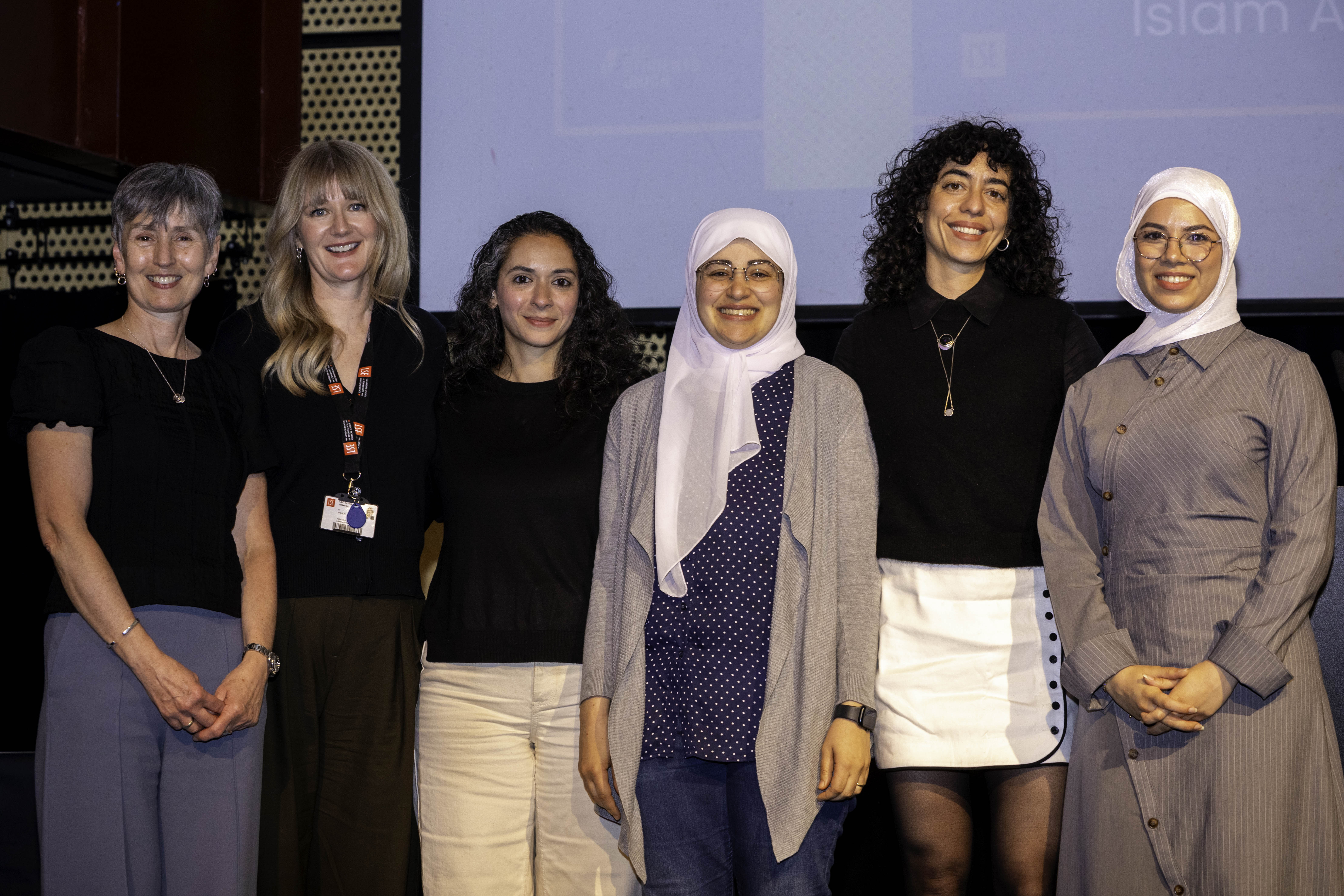 a group photo of methodology academics standing on stage