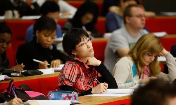 student sitting in a lecture theatre taking notes