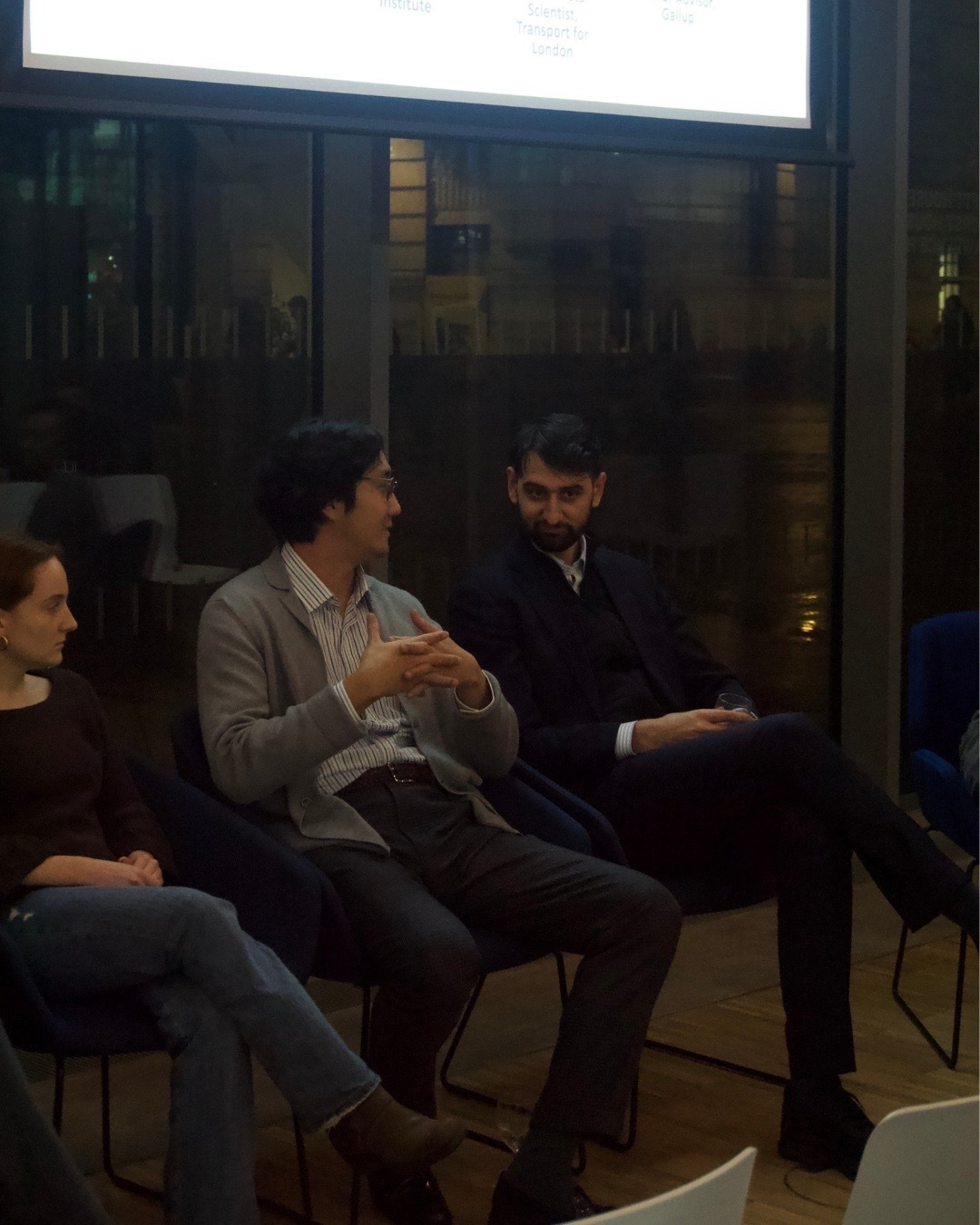 three people sit in a row on a panel