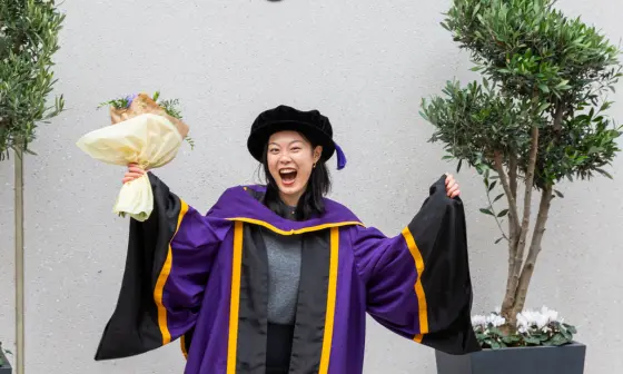 A PhD student celebrating at graduation
