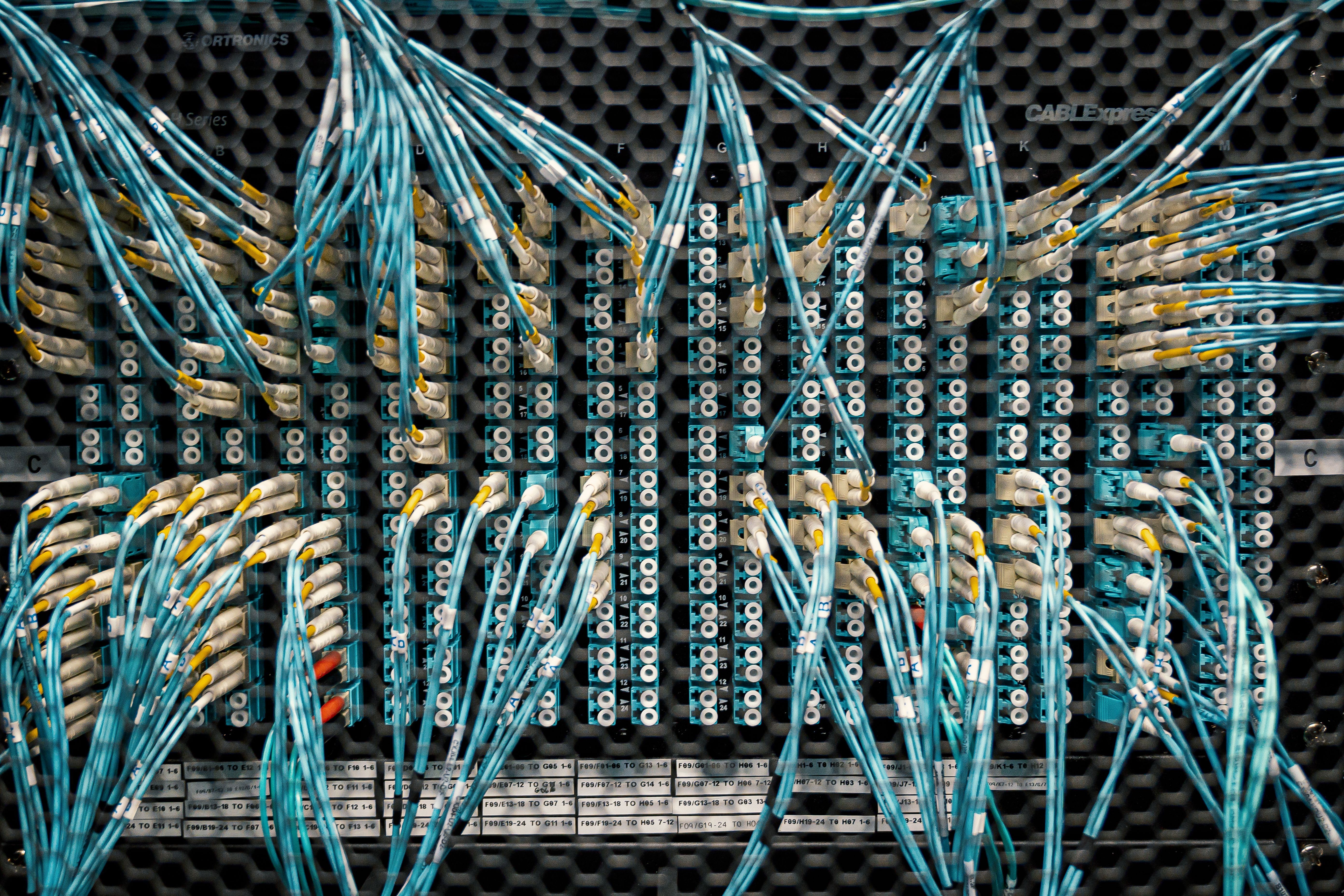 Multiple cables plugged into a board of plugs
