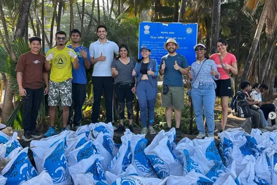 Alumni in Mumbai pose with large sacks following a beach clean