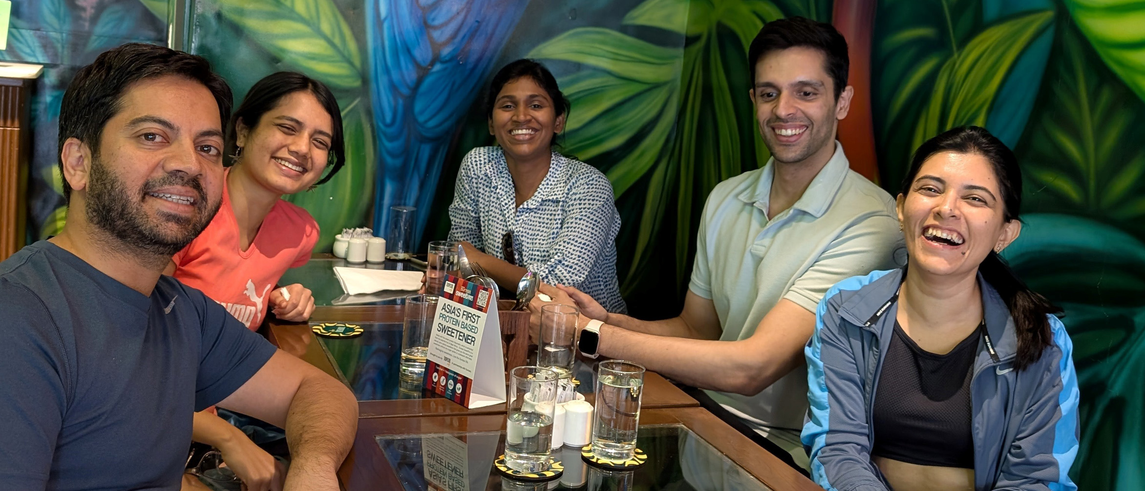 Alumni gather around a table during an alumni event in Mumbai