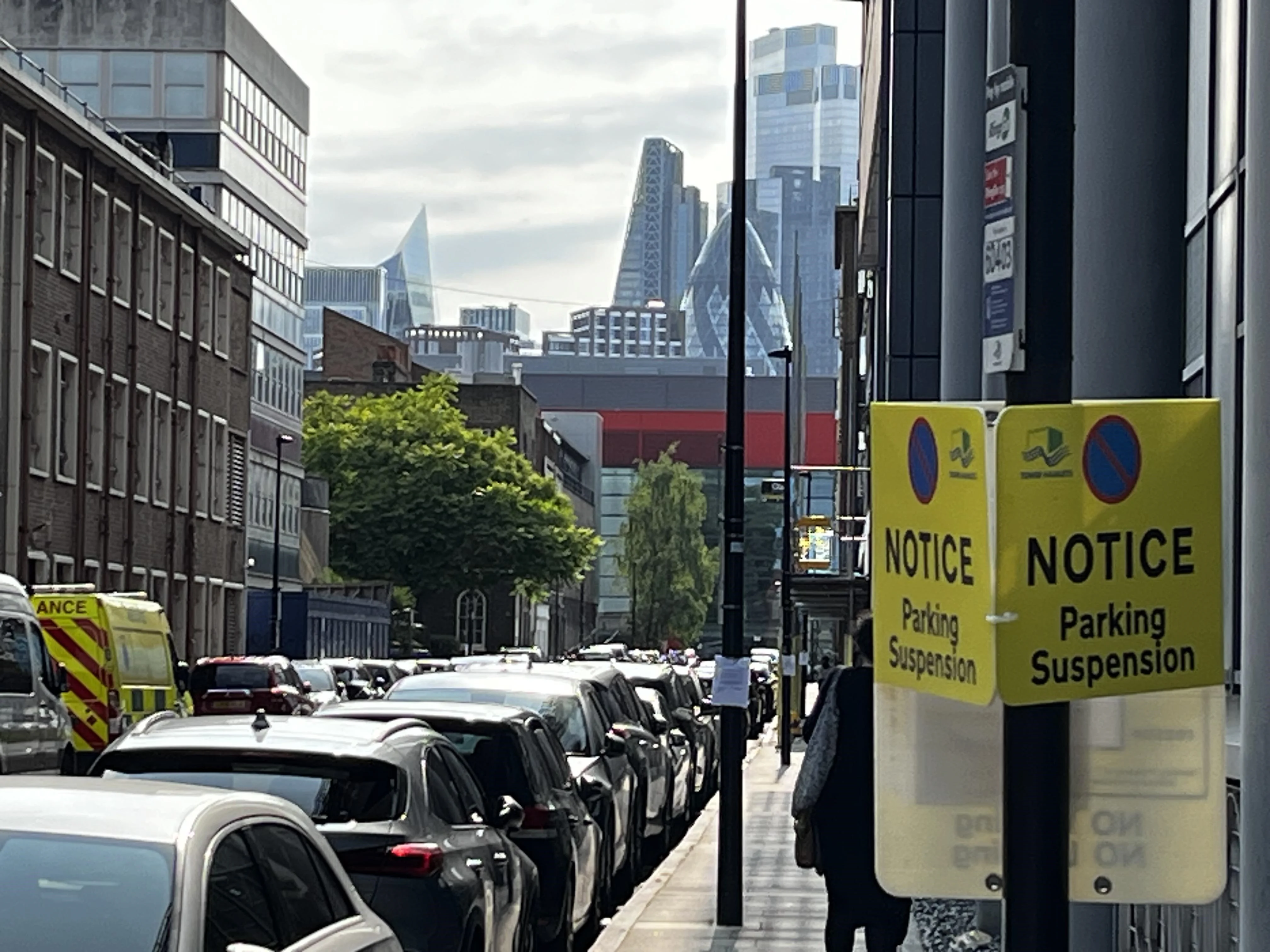 Cars parked in London with skyscrapers behind