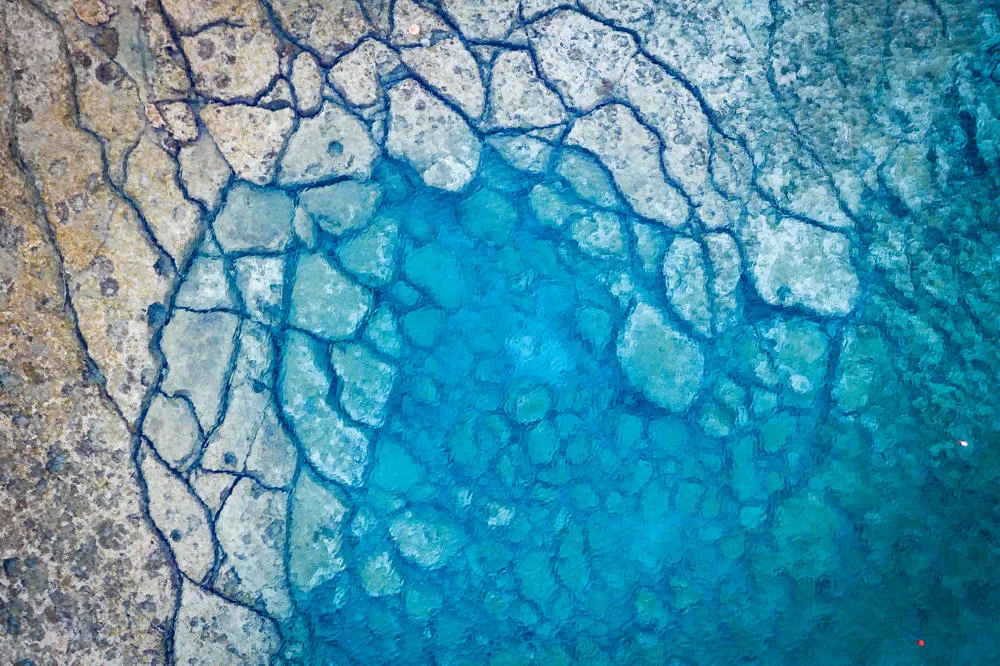 An aerial view of Mediterranean Sea, cracked rocky textured underwater corals