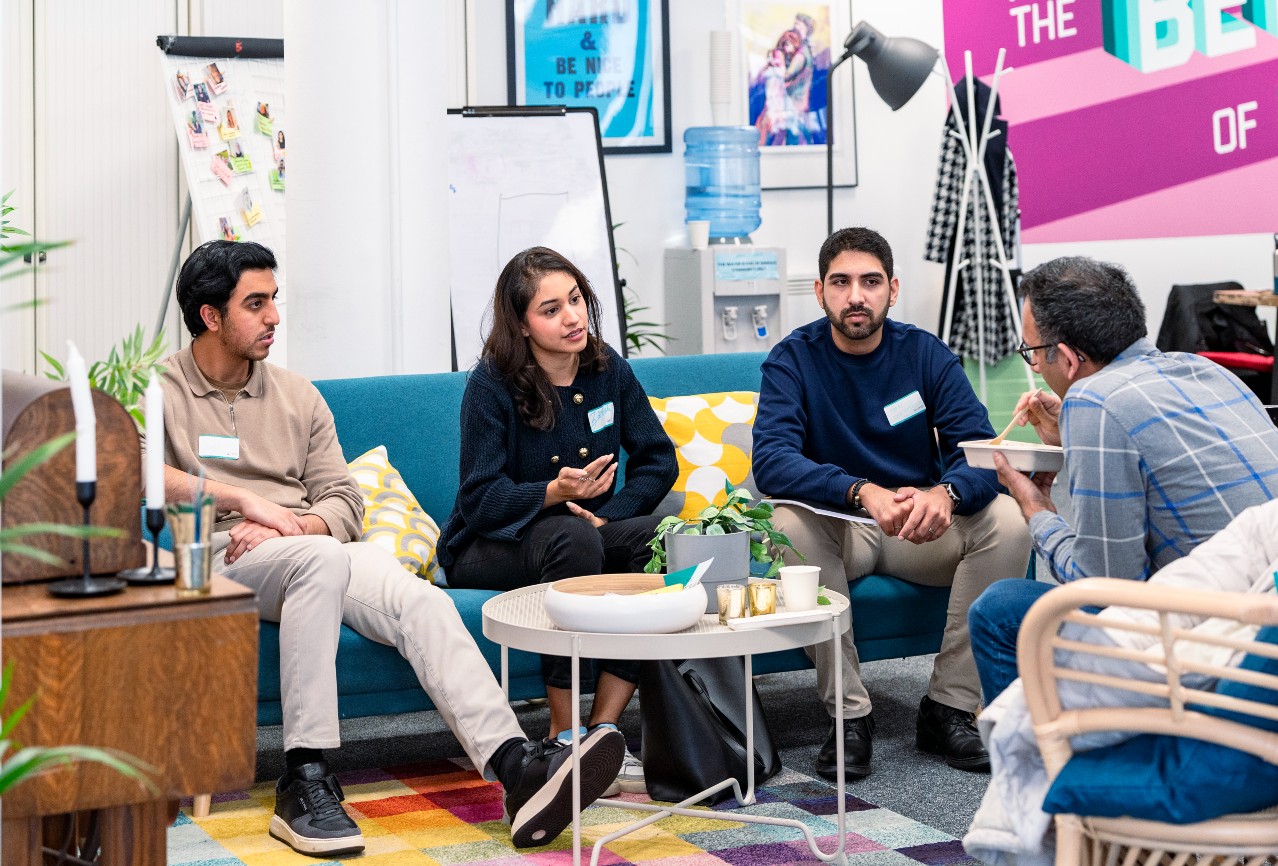 Four people sit and talk in LSE's Generate''s hub, the Gen Den