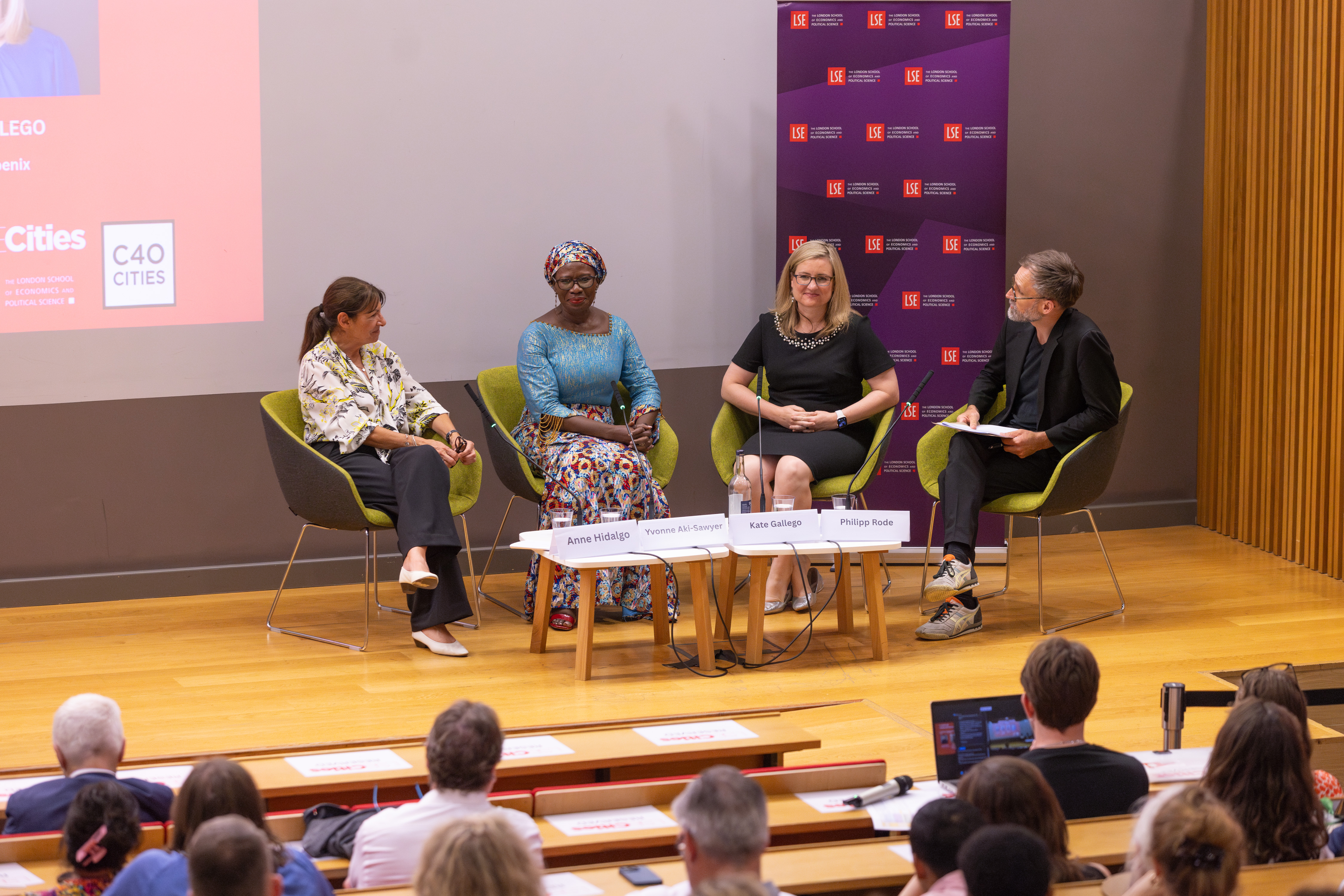 The panellists and Chair sit on chairs on stage during a panel discussion: 