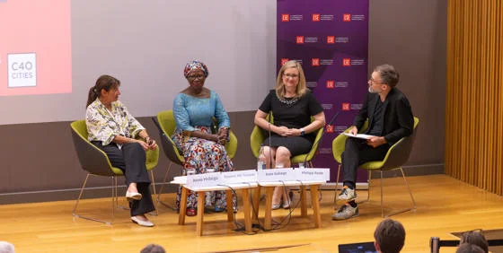The panellists and Chair sit on chairs on stage during a panel discussion: