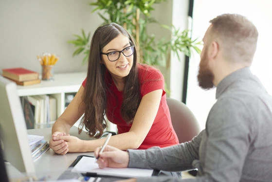 Man and woman talking at a desk
