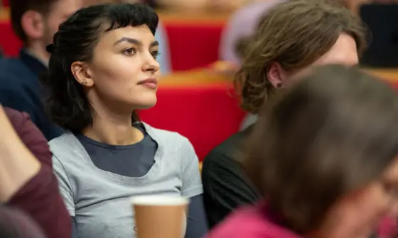 A woman listening to a lecture