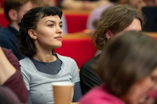 A woman listening to a lecture