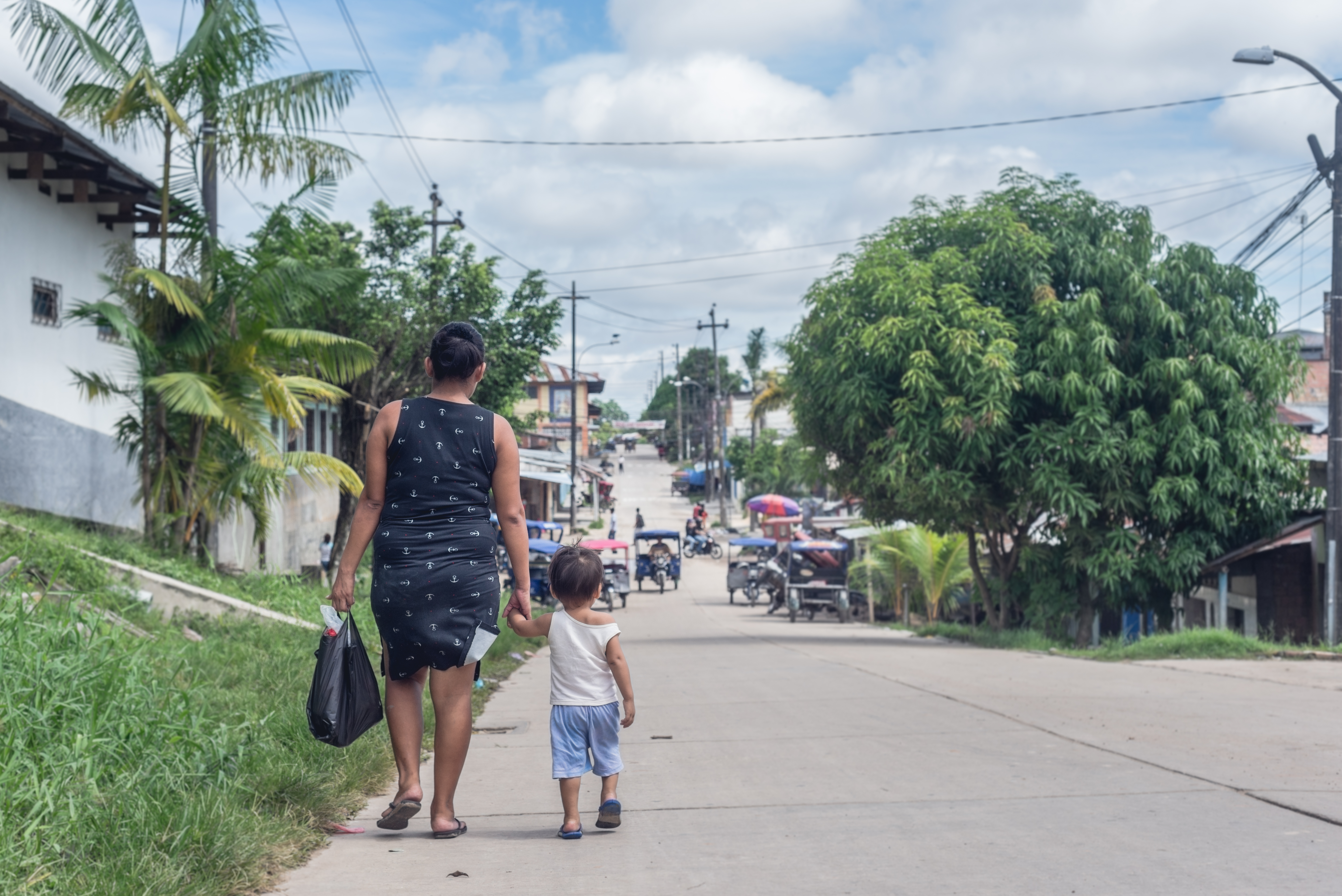 Parent and child walking down a street in the Global South