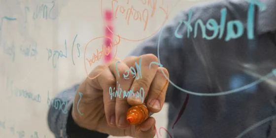 Someone drawing on a transparent board