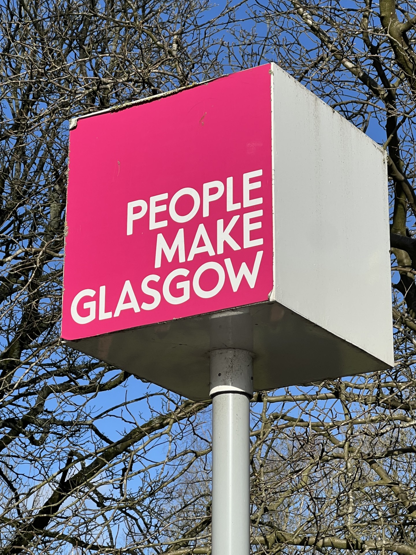 "People make Glasgow" slogan on a sign with a pink background