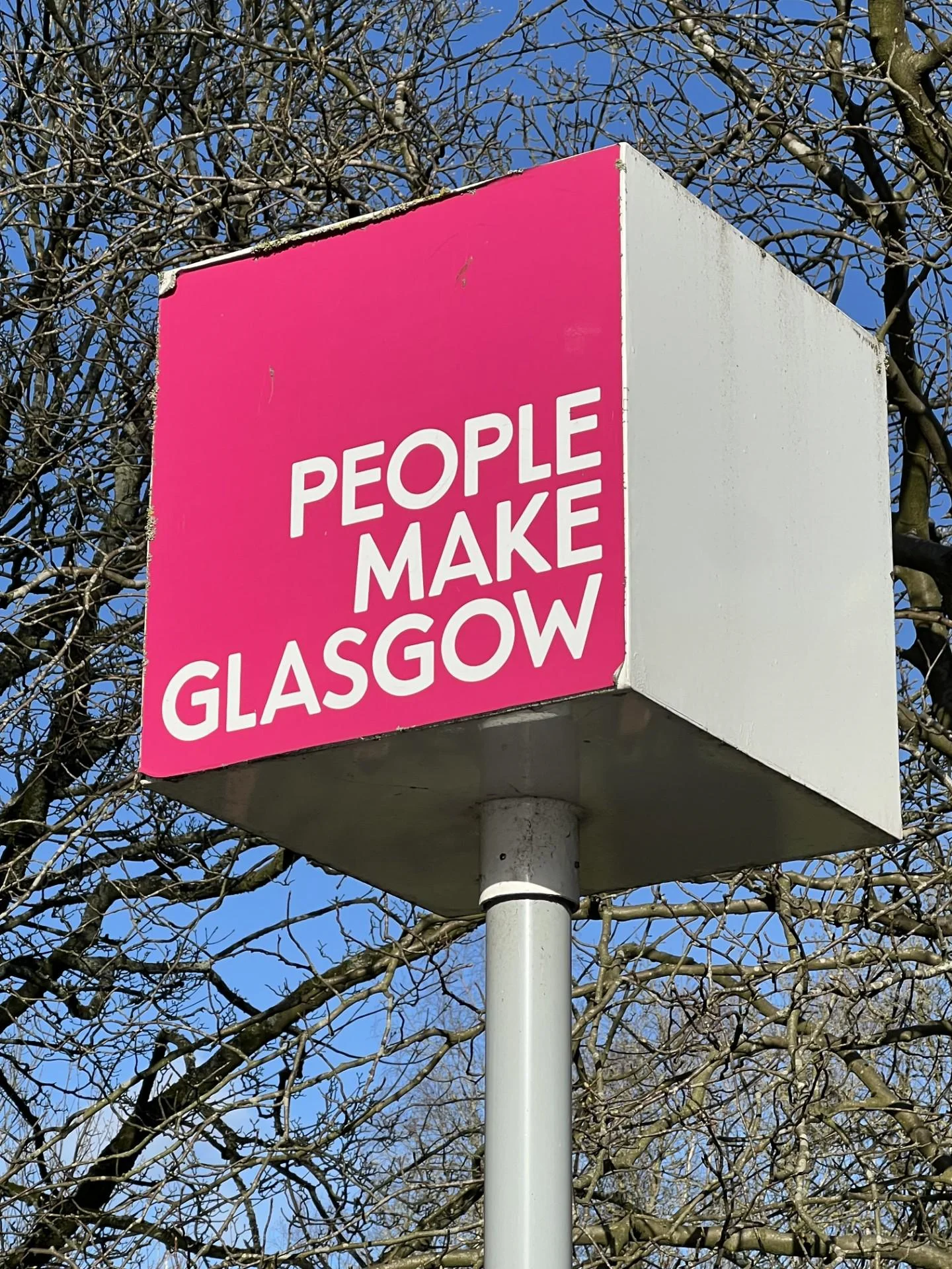 "People make Glasgow" slogan on a sign with a pink background