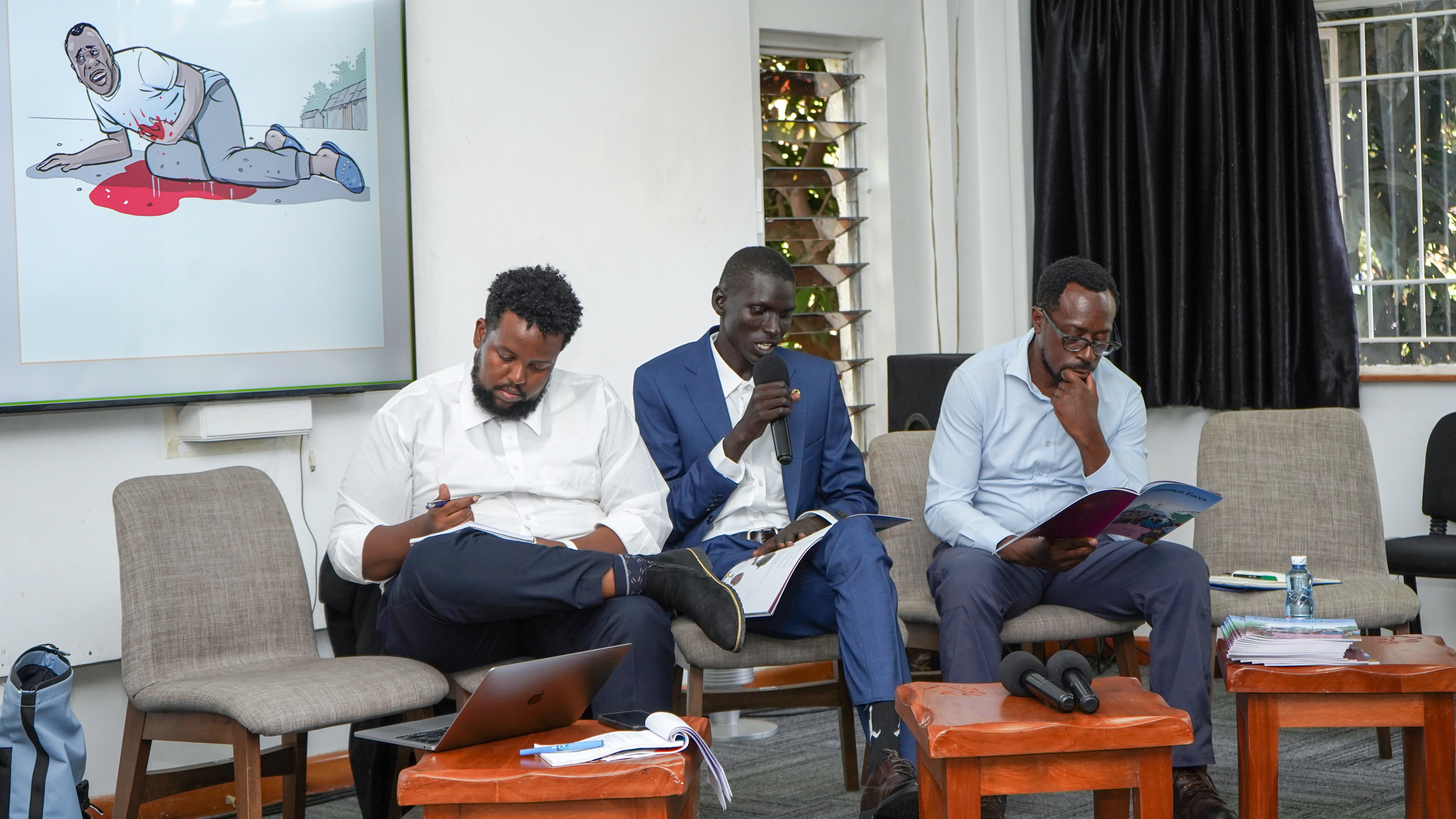 Peter Kidi reading from the booklet