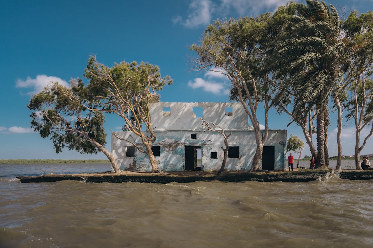 Abandoned building surrounded by water and trees during floods