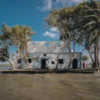 Abandoned building surrounded by water and trees during floods