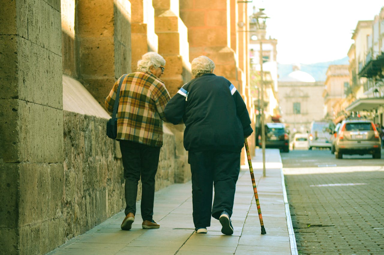 Two elderly people walking side by side