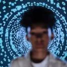 Blurred figure standing before a circular pattern of glowing binary code numbers