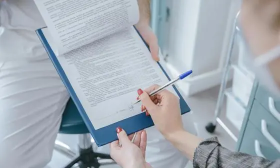 Someone signing a clipboard