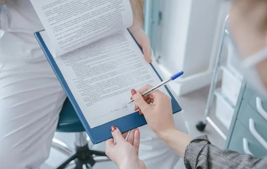 Someone signing a clipboard