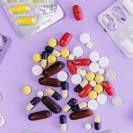 Top-down view of mixed capsules, tablets, and soft gel pills in various colours