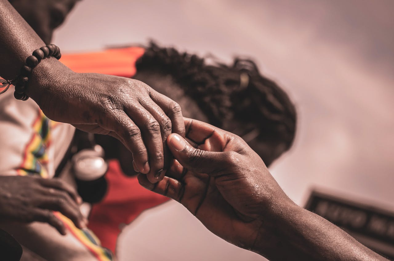 Close view of two people holding hands gently, showing support, care, and connection