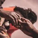 Close view of two people holding hands gently, showing support, care, and connection