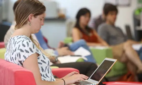 Student in PhD Academy typing on laptop