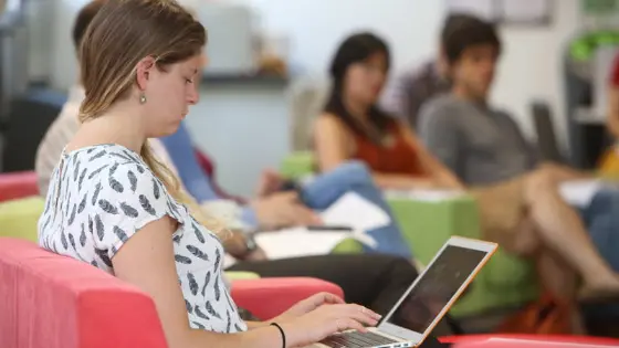 Student in PhD Academy typing on laptop