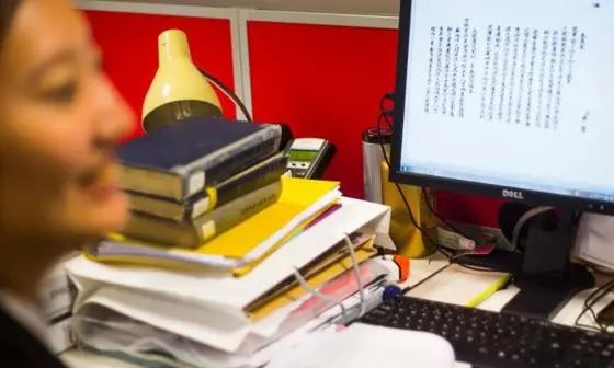 Student at desk with screen and books