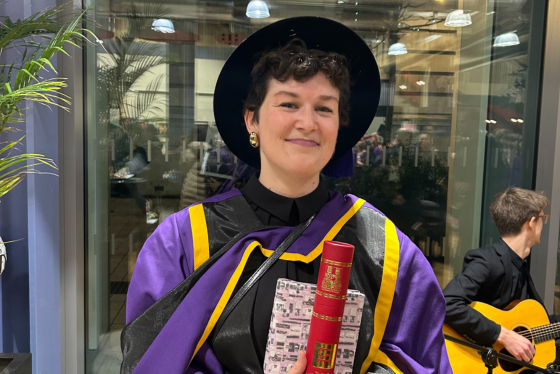A PhD student smiling at graduation