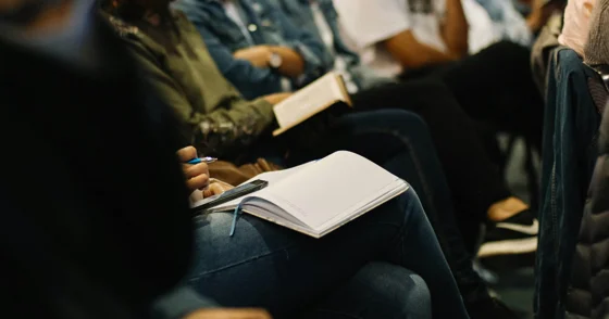 people at a conference taking notes