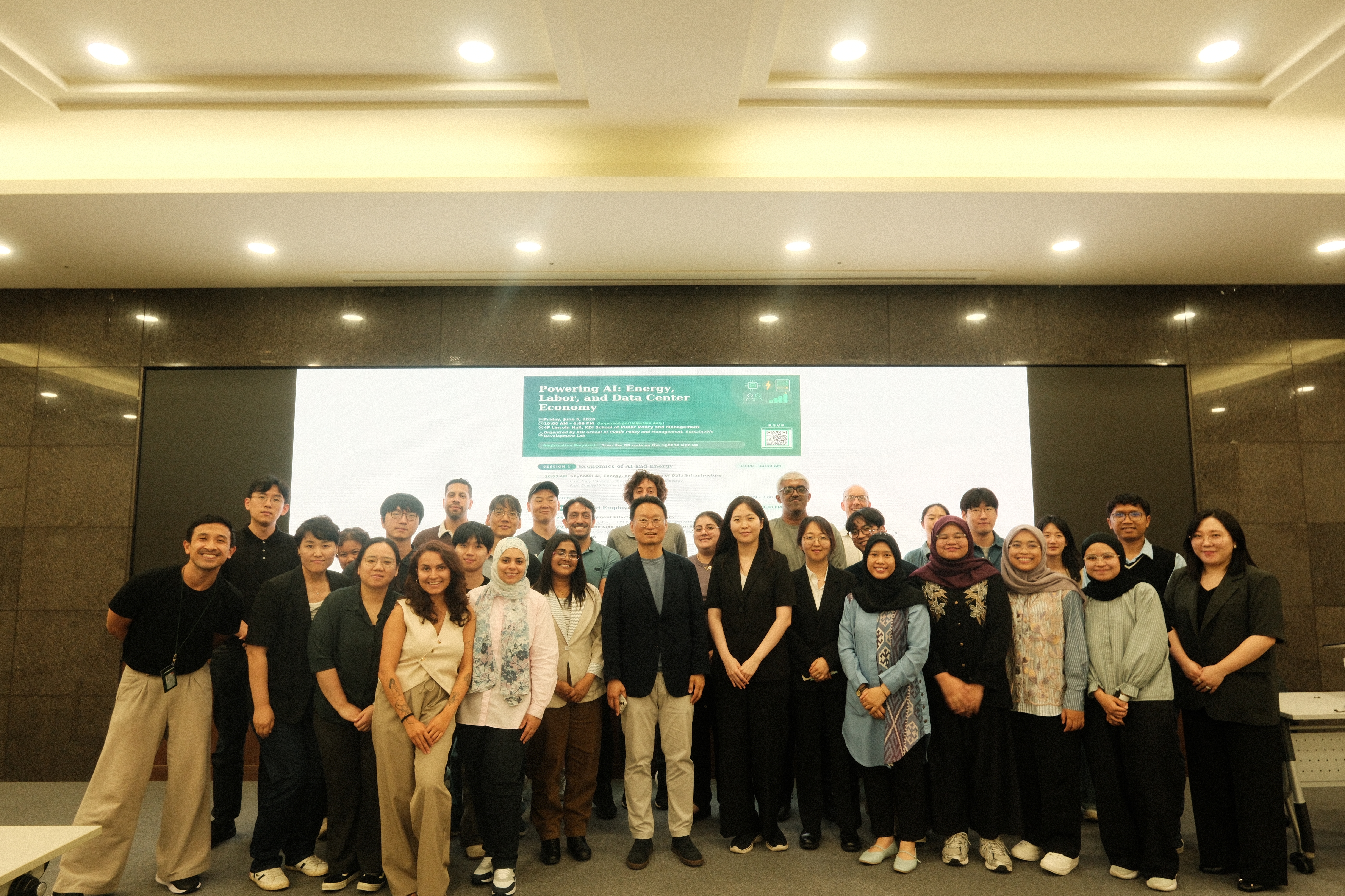 A group of attendees from the workshop posing at the front of the room. 