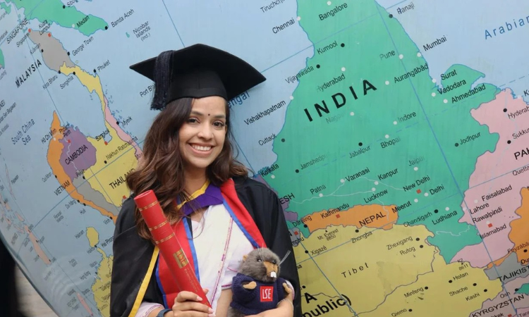 Prakriti Dhakal at graduation standing by LSE globe