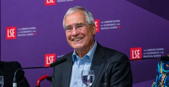 Nicholas Stern on a stage of a lecture theatre.