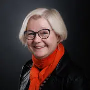 Headshot of Janet Foster. She is smiling and wearing a red scarf.