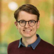 Headshot of a man with glasses smiling at the camera