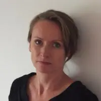 Woman standing against white wall