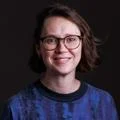Haley McAvay headshot - she is smiling and wearing a blue jumper.