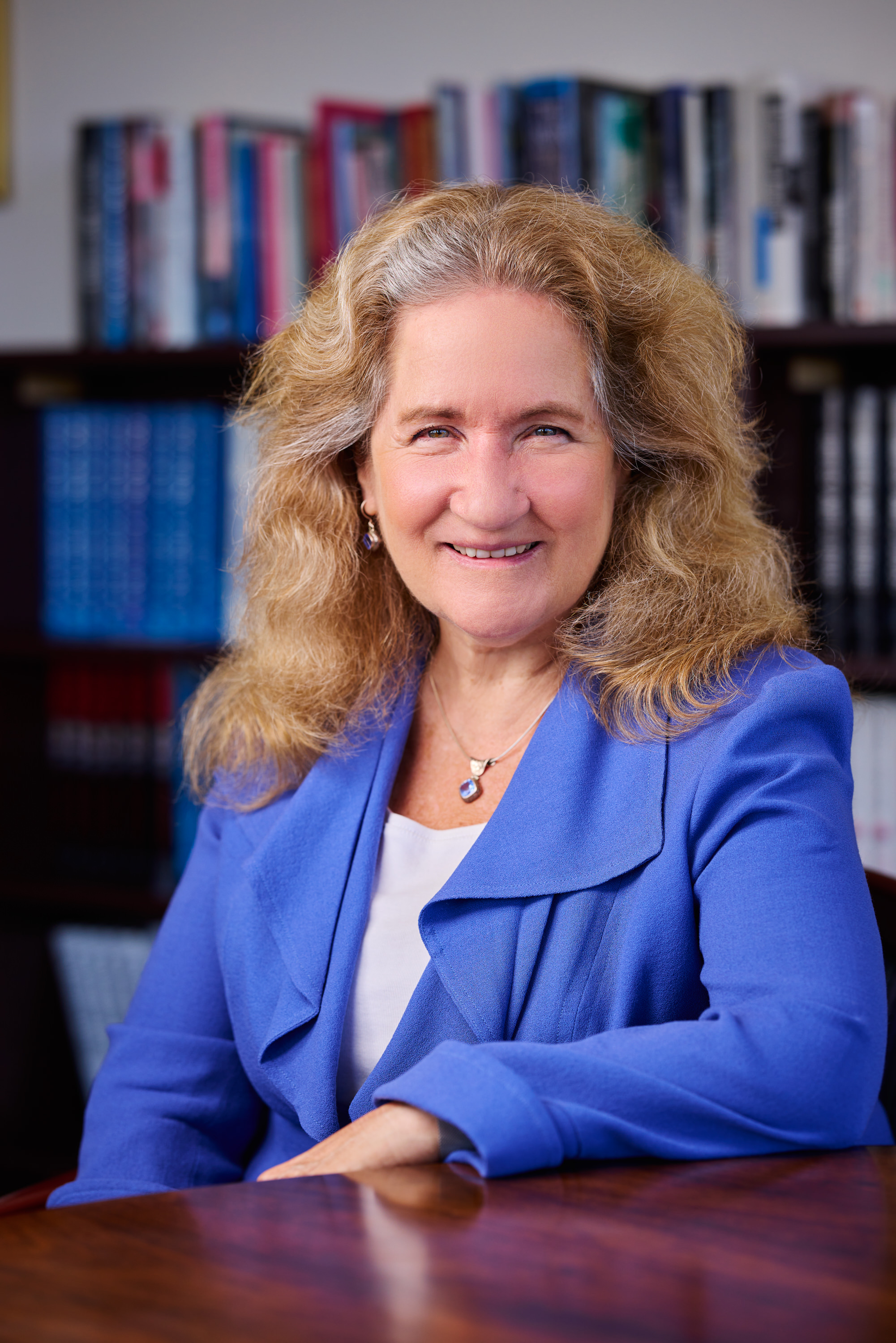 Katherine Newman is wearing a blue jacket and facing the camera smiling.