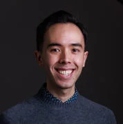 Nicholas Pang, he is smiling against a grey backdrop.