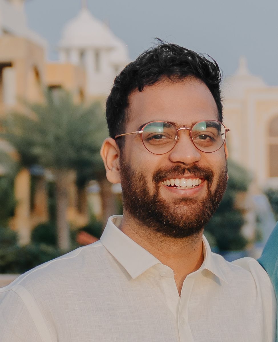 headshot of a man with glasses smiling at the camera