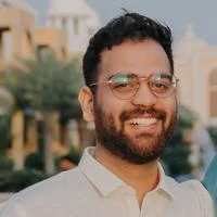 headshot of a man with glasses smiling at the camera
