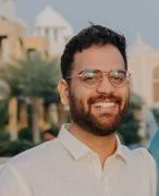 headshot of a man with glasses smiling at the camera