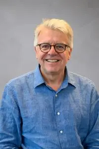 Headshot of Stephan Chambers in a blue shirt against a grey background