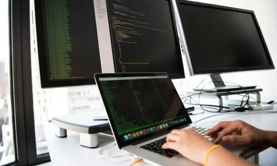 Global-Programmes-laptop-and-bank-of-monitors-with-data