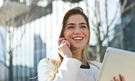 Global-Programmes-smiling-young-executive-on-phone-outside-glass-building