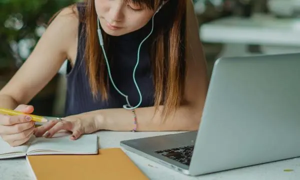 Global_Programmes_studnet_writing_notes_at _desk
